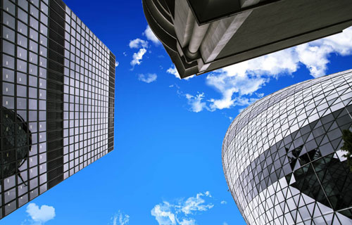Clear blue sky with three sky scrapers in frame.