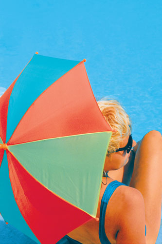 Woman at a pool with an umbrella.